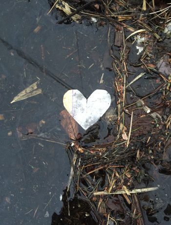 foil heart on a wet sidewalk with leaves & debris