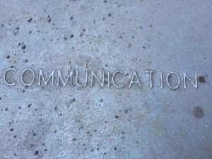 the word "communication" in relief on a metal grate